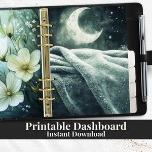 Puede incluir: Un planificador negro con encuadernación dorada, con una ilustración de ensueño de flores blancas, una luna creciente y una manta texturizada. El texto "Printable Dashboard Instant Download" está en la parte inferior.