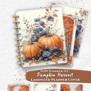 May include: Laminated planner cover with a pumpkin harvest theme. The cover features two large orange pumpkins, blue flowers, and autumn foliage. Additional covers show autumn landscapes. The planner has gold-coloured rings.