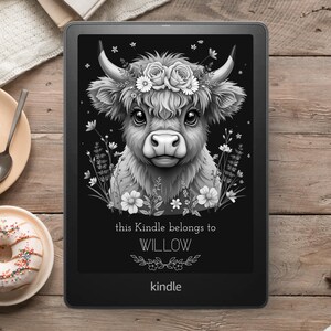 May include: Black and white illustration of a Highland cow with a floral crown on a black background. The text "this Kindle belongs to WILLOW" is below the image. The word "kindle" is at the bottom of the image.
