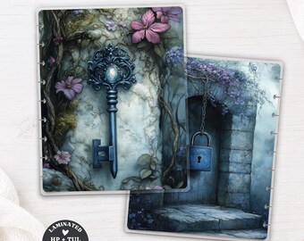 May include: Two laminated planner dashboards featuring fantasy illustrations. One shows an ornate blue key against a stone wall with purple flowers. The other depicts a blue padlock hanging from a stone archway. Both have punched edges for binding.