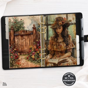 May include: A black six-ring binder containing a dashboard insert with a printed illustration of a wooden gate, a garden path, and a person wearing a wide-brimmed hat reading a book. A silver pen is attached to the side of the binder.