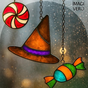 Puede incluir: Decoraciones de Halloween de vidrieras, que incluyen un sombrero de bruja con una banda morada, un caramelo y una espiral roja y blanca. Cada pieza cuelga de una cadena. El fondo es borroso y de color neutro.