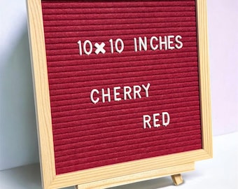 Puede incluir: Un tablero de letras de fieltro cuadrado con fondo rojo cereza y marco de madera clara. El tablero presenta letras de plástico blanco que deletrean 10x10 INCHES, CHERRY y RED. El tablero se muestra sobre un pequeño caballete de madera.