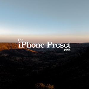 Puede incluir: Fotografía de paisaje con una cordillera bajo un cielo azul y naranja. El texto blanco dice "The iPhone Preset pack" con un pequeño logotipo "S" en la parte inferior.