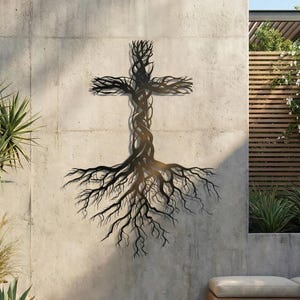 May include: A metal wall art piece depicting a cross formed from a tree, with roots extending downwards. The artwork is dark brown and mounted on a concrete wall, creating a striking contrast. The design evokes a sense of nature and spirituality.