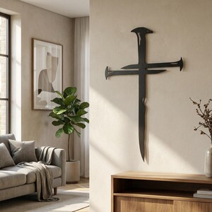 May include: A black metal cross wall art piece with a unique design, featuring stylized nails at the ends of the cross and a textured vertical element. The artwork is mounted on a neutral-colored wall in a living room setting.