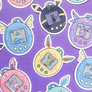 May include: A selection of colourful stickers depicting Pokémon characters within retro-style handheld game devices. The stickers are in shades of pink, blue, yellow, purple, and black, with detailed illustrations of the Pokémon.