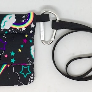 May include: A black fabric pouch with a rainbow, stars, and clouds print. The pouch has a black strap with a silver carabiner clip.