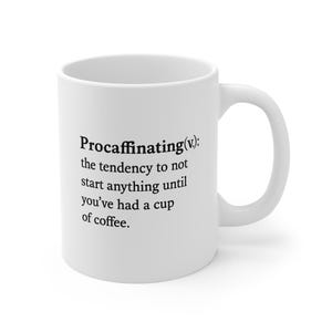 Puede incluir: Taza de café de cerámica blanca con la definición de "Procaffinating" impresa en negro. La definición dice: la tendencia a no empezar nada hasta que hayas tomado una taza de café.