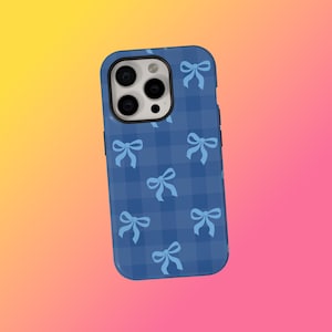 Pode incluir: Uma capa de telefone azul com um padrão xadrez e laços azuis claros. A capa tem uma borda preta e cobre a parte traseira e as laterais do telefone. As lentes da câmera do telefone são visíveis.