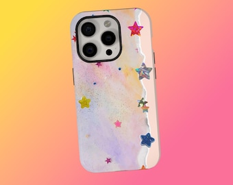 May include: A smartphone case with a colorful watercolor design. The case features a mix of pink, purple, and blue hues, with scattered glitter and star-shaped embellishments in various colors. The case has a white border and a camera cutout.
