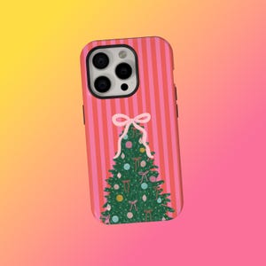May include: A pink and red striped phone case featuring a Christmas tree design. The green tree is decorated with colorful ornaments and bows. The case is designed to fit a smartphone and has camera cutouts.