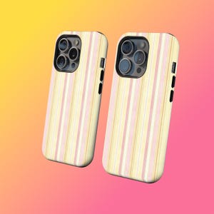 May include: Two phone cases with a vertical striped pattern in pastel yellow, pink, and white. The cases have a black border and camera housing. The background gradient transitions from yellow to pink.