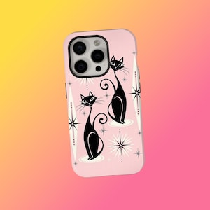 Puede incluir: Una funda de teléfono rosa con un diseño retro. Presenta dos gatos negros y detalles de estrellas. Los gatos tienen colas largas y curvas y están sobre un fondo rosa claro. La funda está diseñada para un smartphone.