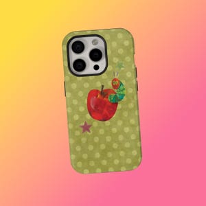 May include: A green iPhone case with a red apple, a cartoon caterpillar, and a star. The case has a polka dot pattern and a black camera lens border.