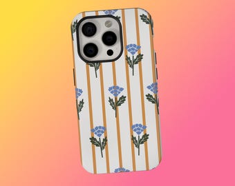 May include: A white phone case with a pattern of vertical gold stripes and blue floral designs. The case has a black camera module and black side buttons. The background is a gradient of yellow, orange, and pink.