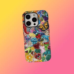 May include: A colorful phone case with a collage of decorative elements. The case features a butterfly, a strawberry, a heart, and other embellishments. The case is designed to fit a smartphone.