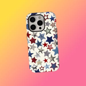 May include: A white phone case featuring a pattern of red, blue, and silver stars. The stars are of varying sizes and textures, some with a denim appearance. The case has a camera cutout and a black border.
