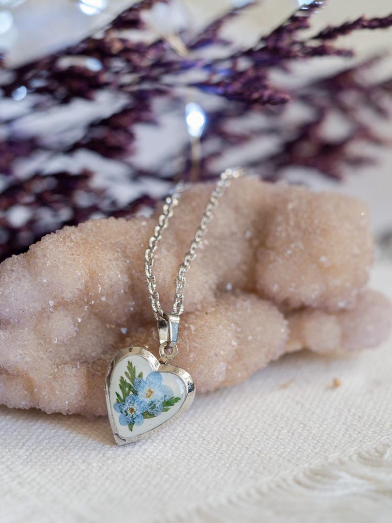 Silver tone pressed flower heart pendant locket shown open with space for tiny photo note