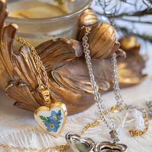 Gold tone stainless steel heart locket holding blue forget me not blooms on 50cm chain