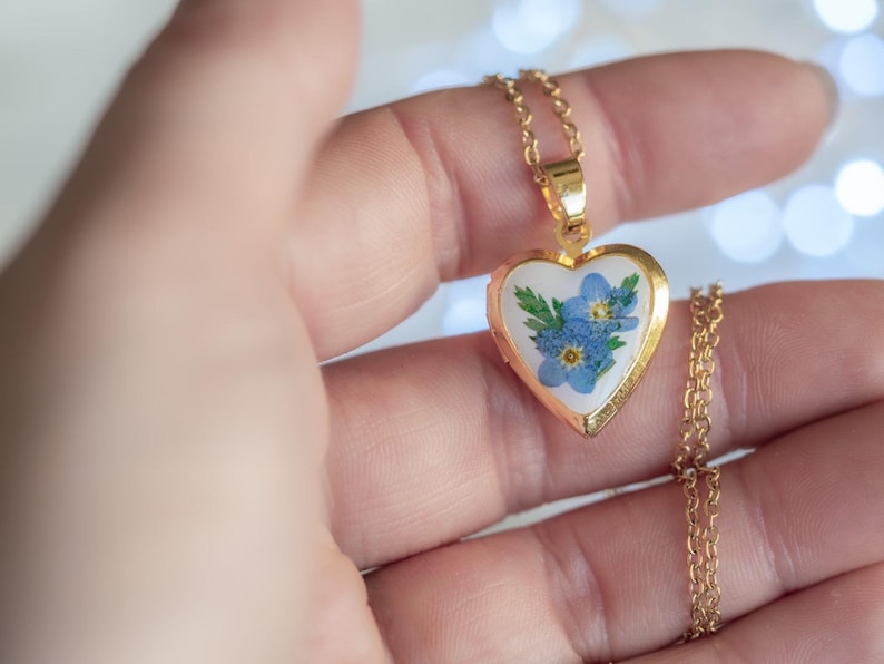 Gold tone stainless steel heart locket holding blue forget me not blooms on 50cm chain