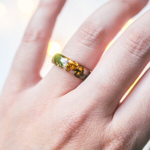 Botanical resin ring with green moss suspended in crystal-clear resin, available with gold, silver, or no flakes.