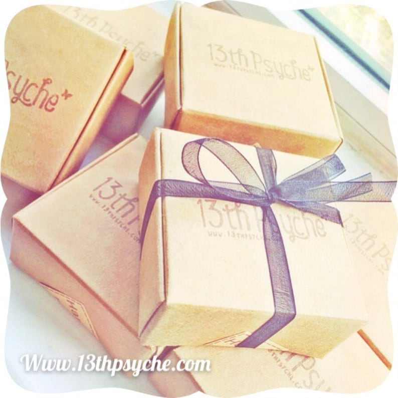 May include: Multiple small, brown cardboard boxes with a black ribbon and bow. The boxes are labeled with the text "13th Psyche" and the website address "www.13thpsyche.com".