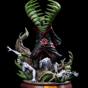May include: A detailed Zetsu statue from the Naruto anime series. The figure features Zetsu in a black Akatsuki cloak with red accents, surrounded by green plant-like structures and two smaller Zetsu figures. The base is brown with a gold nameplate.