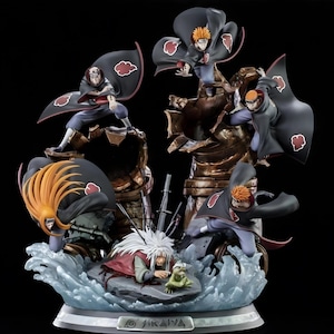 Puede incluir: Figura detallada con personajes de la serie de anime Naruto. Las figuras están posadas dinámicamente, con una figura central rodeada de otras en poses de acción. La base es una mezcla de elementos de agua y roca, con un fondo oscuro.