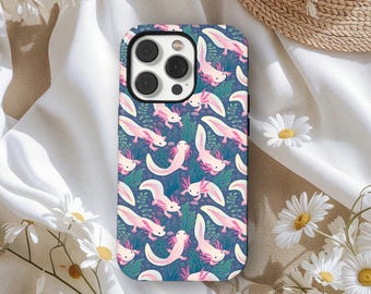 Peut inclure: Coque de téléphone avec un motif répétitif d'axolotls roses sur un fond bleu foncé avec des plantes aquatiques vertes et bleues. Les axolotls ont des branchies roses et sont dans diverses poses. Le boîtier a un module caméra noir.