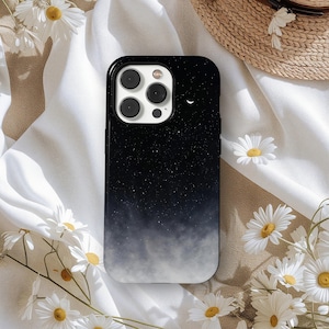 May include: Black smartphone case with a starry night design. The case features a gradient effect, transitioning from a dark, star-filled sky to a misty, cloud-like appearance at the bottom. A crescent moon is visible near the top.