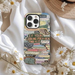 May include: A colorful phone case with a collage of inspirational quotes and phrases. The case features a variety of fonts and colors, with phrases like "If you're looking for a sign, this is it."