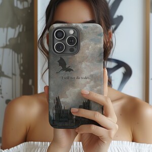 Op de afbeelding: Smartphonehoesje met een fantasiethema. Het heeft een draak silhouet, een kasteel illustratie en de tekst "I will not die today." De achtergrond heeft een wolkachtig, aquarelachtig effect.