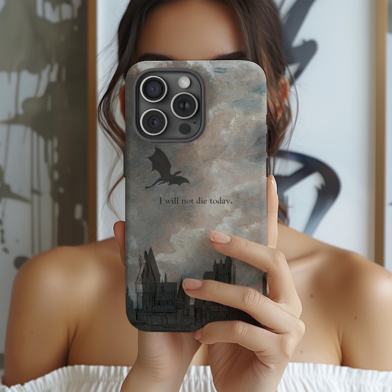 Op de afbeelding: Smartphonehoesje met een fantasiethema. Het heeft een draak silhouet, een kasteel illustratie en de tekst "I will not die today." De achtergrond heeft een wolkachtig, aquarelachtig effect.