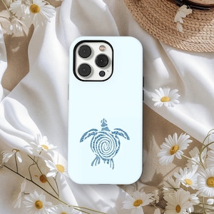 May include: A pale blue phone case with a blue sea turtle design. The turtle is centrally placed and has a spiral pattern on its shell. The case has a black camera module. White daisies surround the phone case.