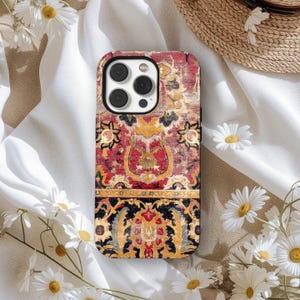 Könnte beinhalten: Eine Handyhülle mit einem detaillierten Vintage-Teppichdesign. Die Hülle zeigt eine reichhaltige Farbpalette aus Rot, Gold und Schwarz mit komplizierten floralen und geometrischen Mustern. Die Hülle hat einen schwarzen Rand und einen Kameraausschnitt.