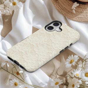 Puede incluir: Una funda de tel&eacute;fono de color crema con un delicado dise&ntilde;o de encaje. La funda tiene un borde negro y est&aacute; dise&ntilde;ada para un tel&eacute;fono inteligente. El intrincado dise&ntilde;o de encaje floral cubre toda la parte posterior de la funda, ofreciendo un toque de elegancia y estilo.