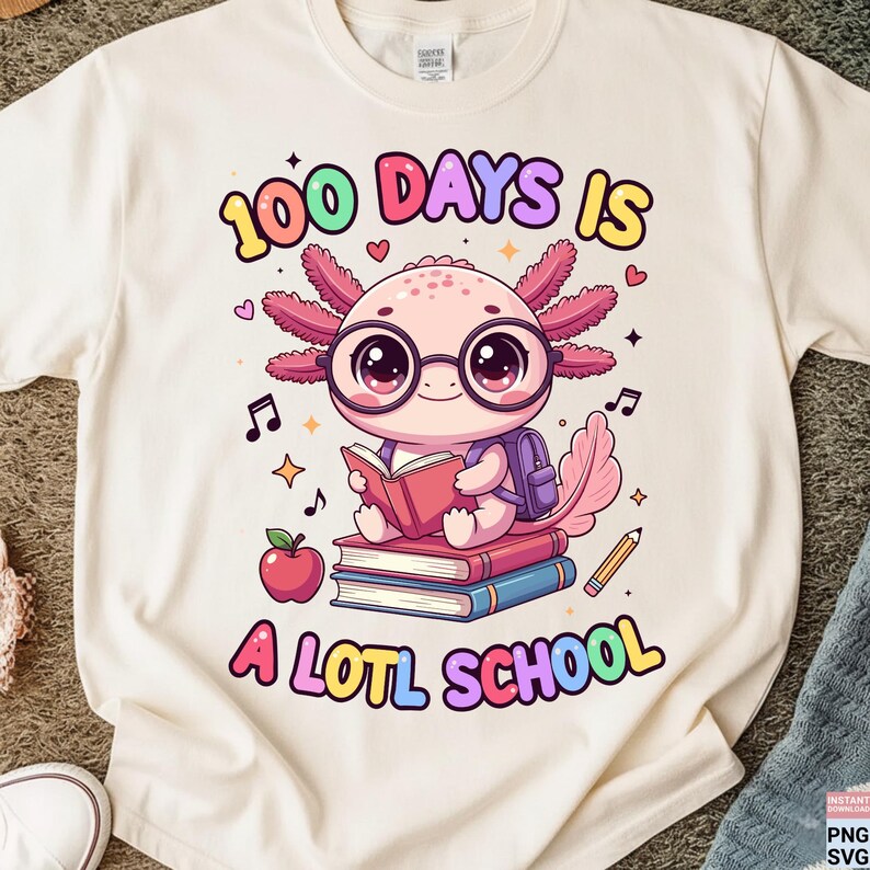 May include: Cream-colored t-shirt featuring a cartoon axolotl wearing glasses and reading a book. The text "100 DAYS IS A LOTL SCHOOL" is printed above and below the axolotl in colorful letters. An apple, pencil, and musical notes are also included.