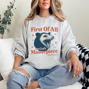First of All I&#39;m God&#39;s Masterpiece Shirt Funny Opossum T Shirt Angry Possum Graphic Tee Sarcastic Animal Bible Verse Ephesians 2:10 Gift