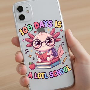 May include: Clear phone case featuring a cartoon axolotl wearing glasses and reading a book. The text "100 DAYS IS A LOTL SCHOOL" is displayed in colorful bubble letters. An apple, pencil, and musical notes are also shown.