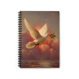 May include: Spiral notebook featuring a painting of a white dove in flight, carrying a green olive branch. The dove is set against a backdrop of a sunset sky with pink and orange clouds, and a reflective water surface.
