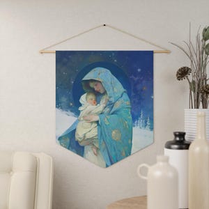 Pode incluir: Uma tapeçaria azul e dourada representando a Virgem Maria segurando um bebê Jesus. A tapeçaria está sobre um fundo azul escuro com estrelas e flocos de neve.