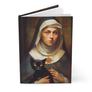 Puede incluir: Diario de tapa dura con un retrato de una mujer con hábito de monja sosteniendo un gato negro. La obra de arte tiene una estética vintage con una paleta de colores de azules, marrones y blancos. El diario está abierto, revelando páginas blancas.