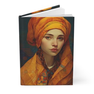 Puede incluir: Diario de tapa dura con un retrato de una mujer con un pañuelo y una chaqueta naranja. La portada muestra la obra de arte sobre un fondo azul oscuro. La mujer tiene el pelo trenzado y una expresión seria. El diario está abierto, revelando páginas blancas.