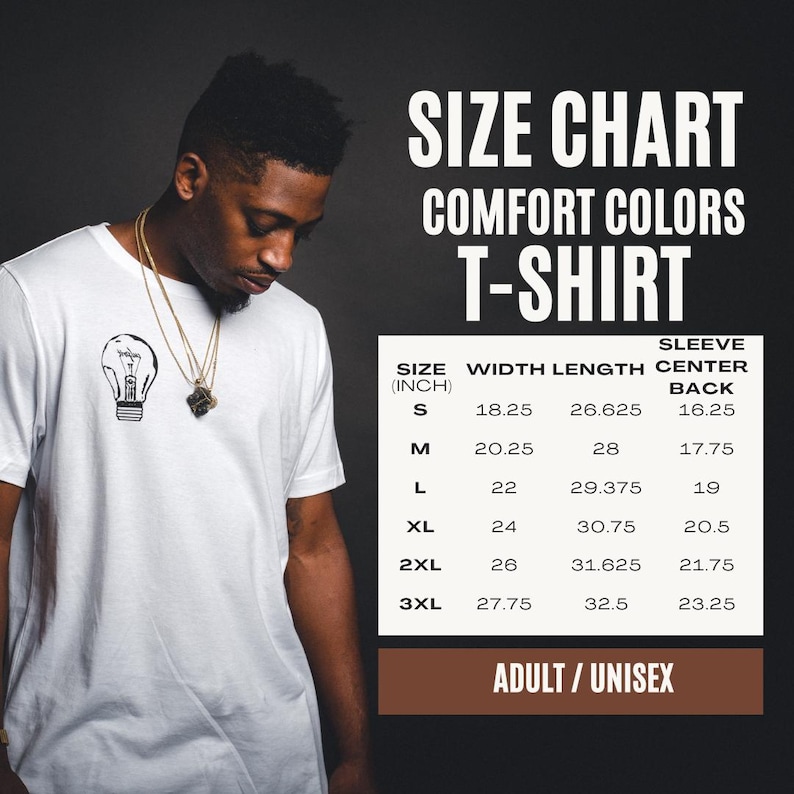 Pu&ograve; includere: Una t-shirt bianca con una piccola grafica di una lampadina nera sul petto. Accanto alla maglietta c'&egrave; una tabella delle taglie per le t-shirt Comfort Colors, che elenca le taglie dalla S alla 3XL con misure in pollici per larghezza e lunghezza.