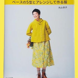 以下が含まれることがあります： 黄色いジャケットと花柄のスカートを着た女性が写った本の表紙。本のタイトルは「ベースの5型とアレンジして作る服」。女性は笑顔で花を持っています。文化出版局発行。