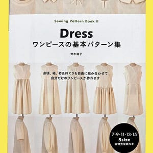 May include: A sewing pattern book titled "Dress" in English and Japanese. The cover features dress designs and text. The book includes sizes 7, 9, 11, 13, and 15. The book is on a yellow background.