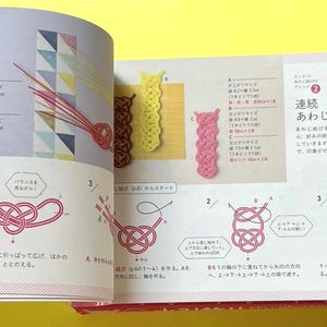 Puede incluir: Libro abierto con texto japon&eacute;s e ilustraciones de t&eacute;cnicas de anudado. Los diagramas muestran instrucciones paso a paso para crear varios nudos, incluido el nudo "Awaji". Se muestran ejemplos de nudos terminados en amarillo, marr&oacute;n y rosa.