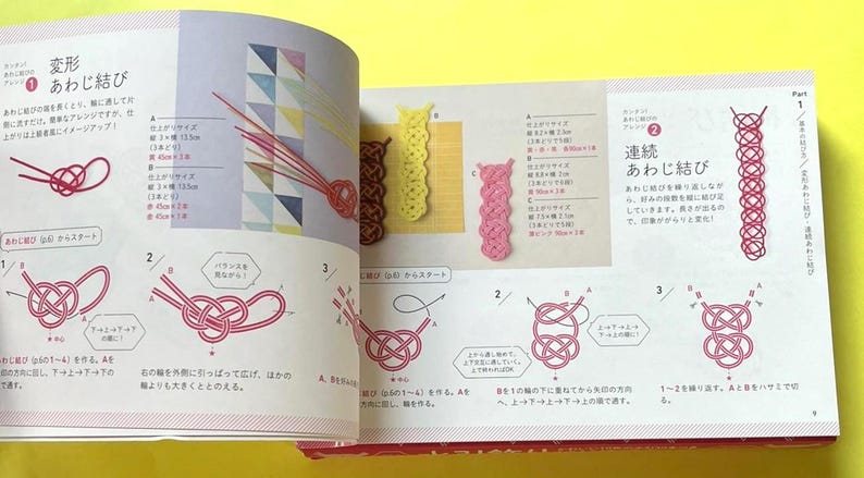Puede incluir: Libro abierto con texto japon&eacute;s e ilustraciones de t&eacute;cnicas de anudado. Los diagramas muestran instrucciones paso a paso para crear varios nudos, incluido el nudo "Awaji". Se muestran ejemplos de nudos terminados en amarillo, marr&oacute;n y rosa.