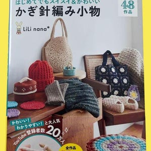 以下が含まれることがあります： 様々なかぎ針編みのプロジェクトが掲載された本の表紙。バッグ、帽子、スリッパなど。表紙には日本語のテキストと完成品のイラストが描かれています。本のタイトルは「かぎ針編み小物」で、著者の名前「LiLi nana*」も含まれています。